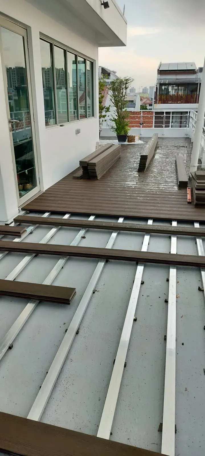 Installer laying composite decking boards onto an aluminium joist frame